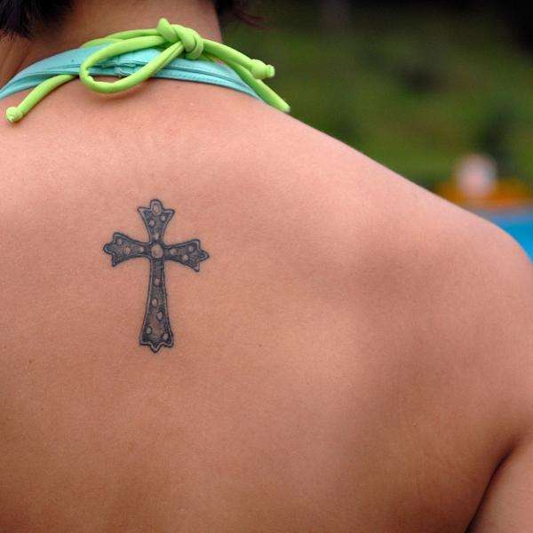 Tatuaje de cruz en la espalda