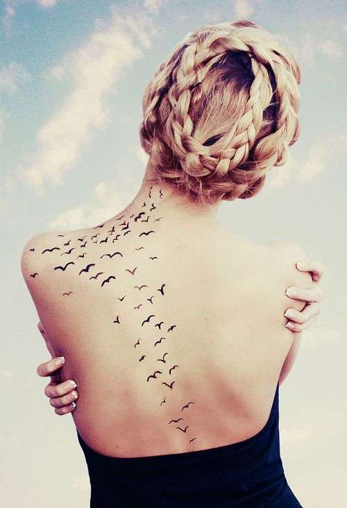 Tatuaje de golondrinas en espalda