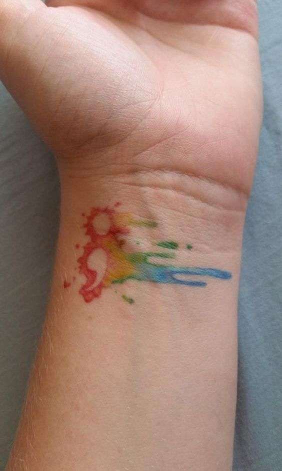 Tatuaje punto y coma sobre mancha de colores