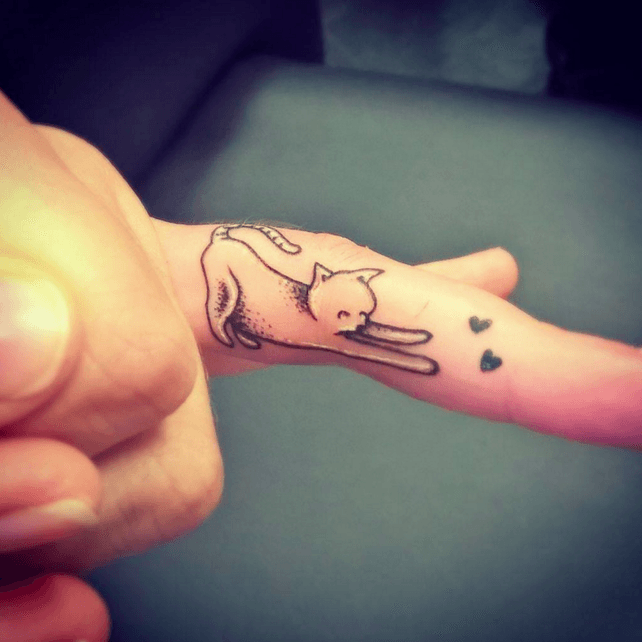 Tatuaje pequeño de gatito en el dedo