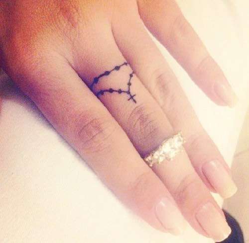 Tatuaje pequeño - rosario en dedo mayor