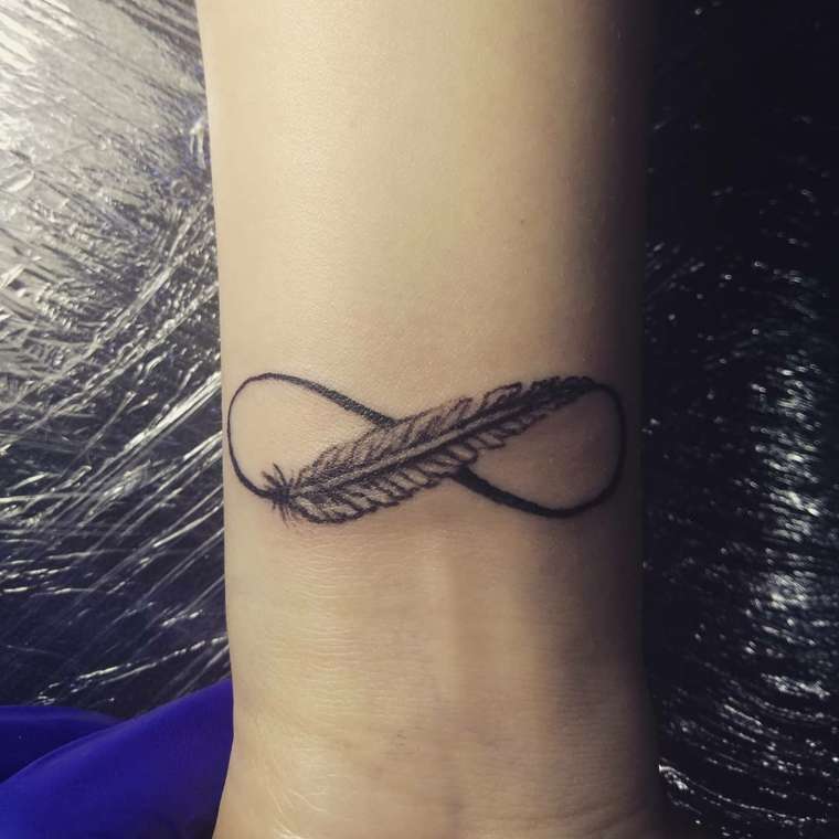 Tatuaje pequeño de pluma en símbolo de infinito