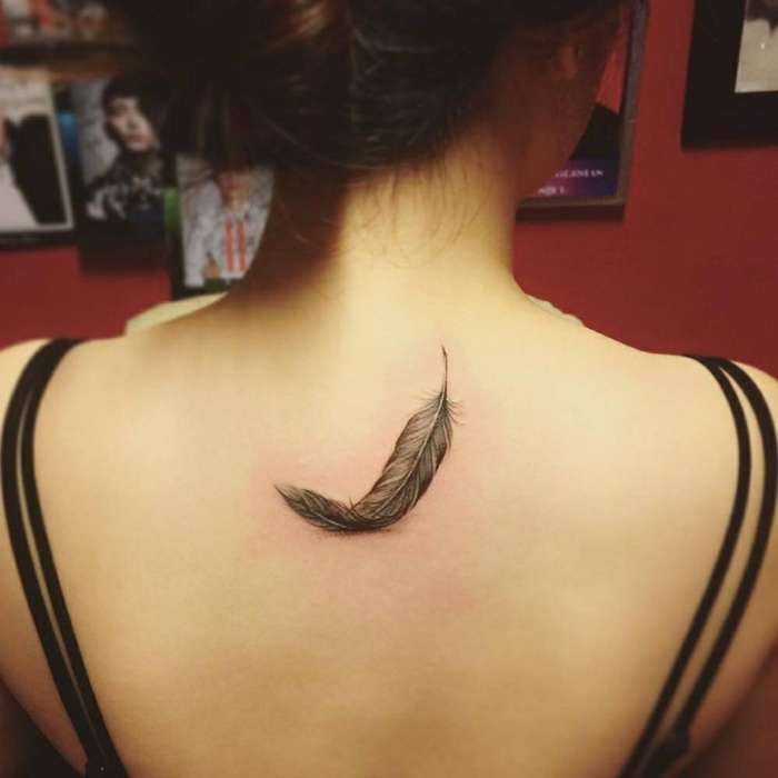 Tatuaje pequeño de pluma en la espalda