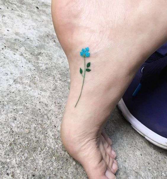 Tatuaje pequeño de flor en el pie