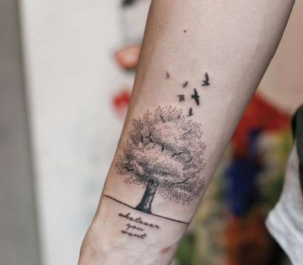 Tatuaje de árbol con aves y frase