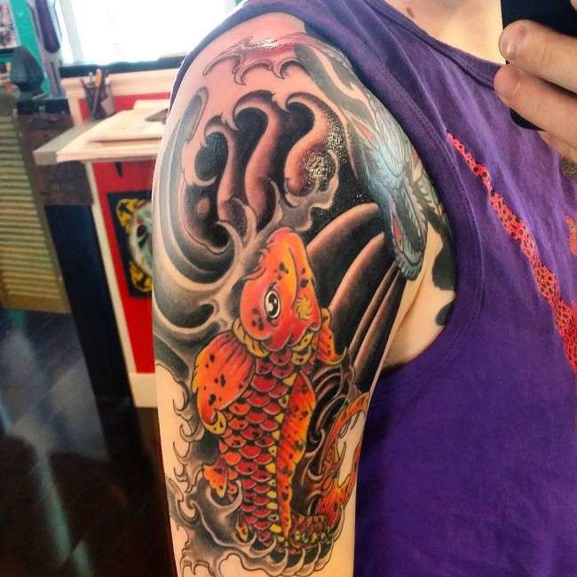 Tatuaje de pez koi naranja en brazo 2