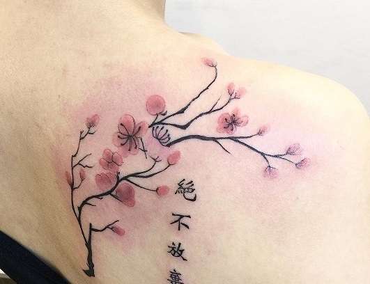 Tatuaje de flor de cerezo con letras japonesas