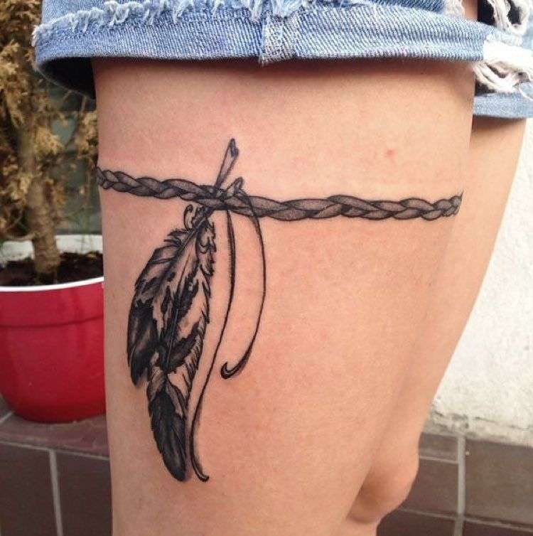 Tatuaje en el muslo tipo liguero - cuerda y plumas