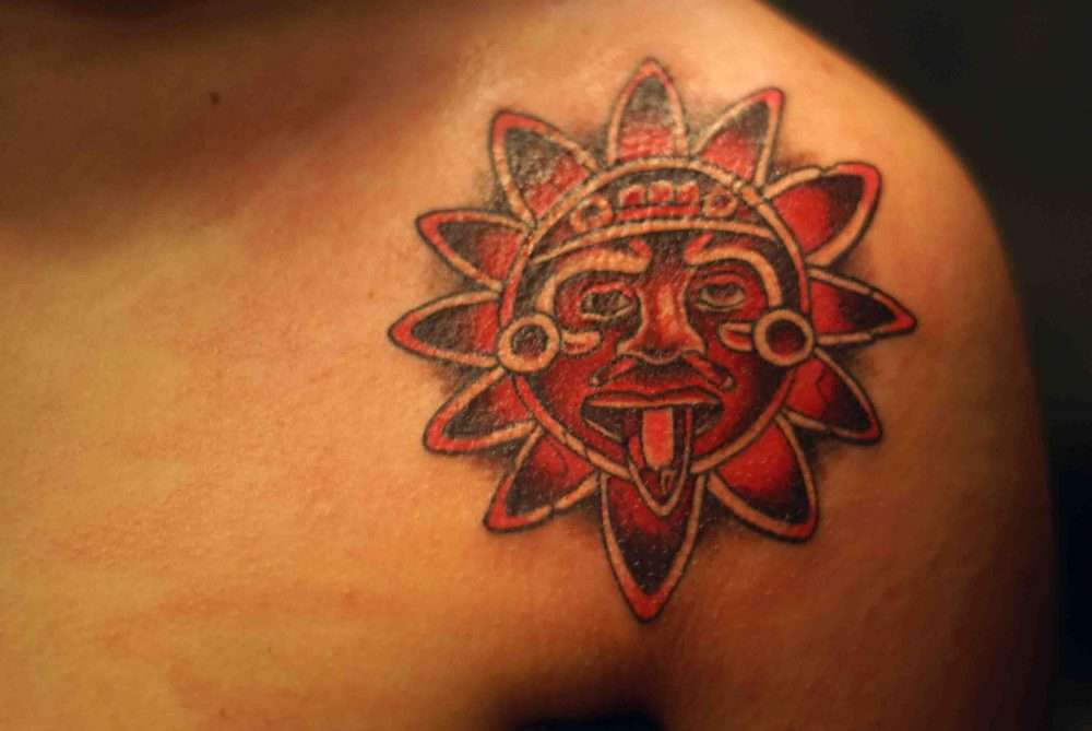 Tatuaje de sol azteca rojo
