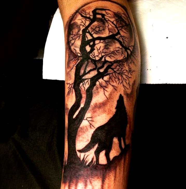 Tatuaje de lobo aullando, luna y bosque