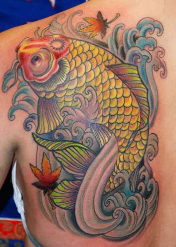 Tatuaje de pez koi amarillo en omóplato