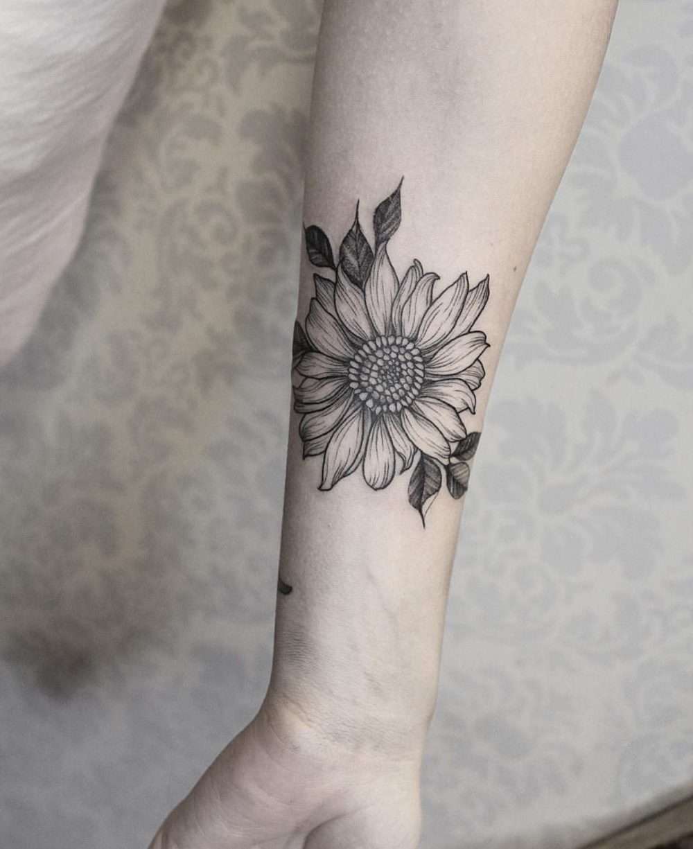 Tatuaje de girasol blanco y negro en antebrazo