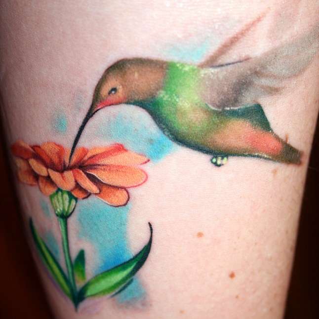 Tatuaje de colibrí libando una flor