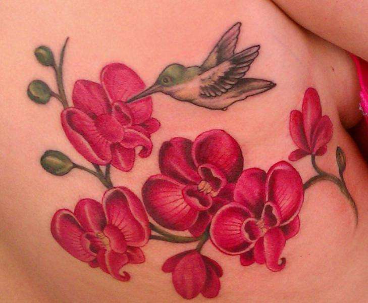 Tatuaje de colibrí y flores color rosa