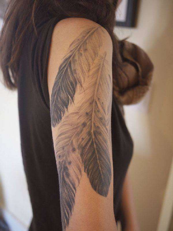 Tatuaje de tres plumas en el brazo