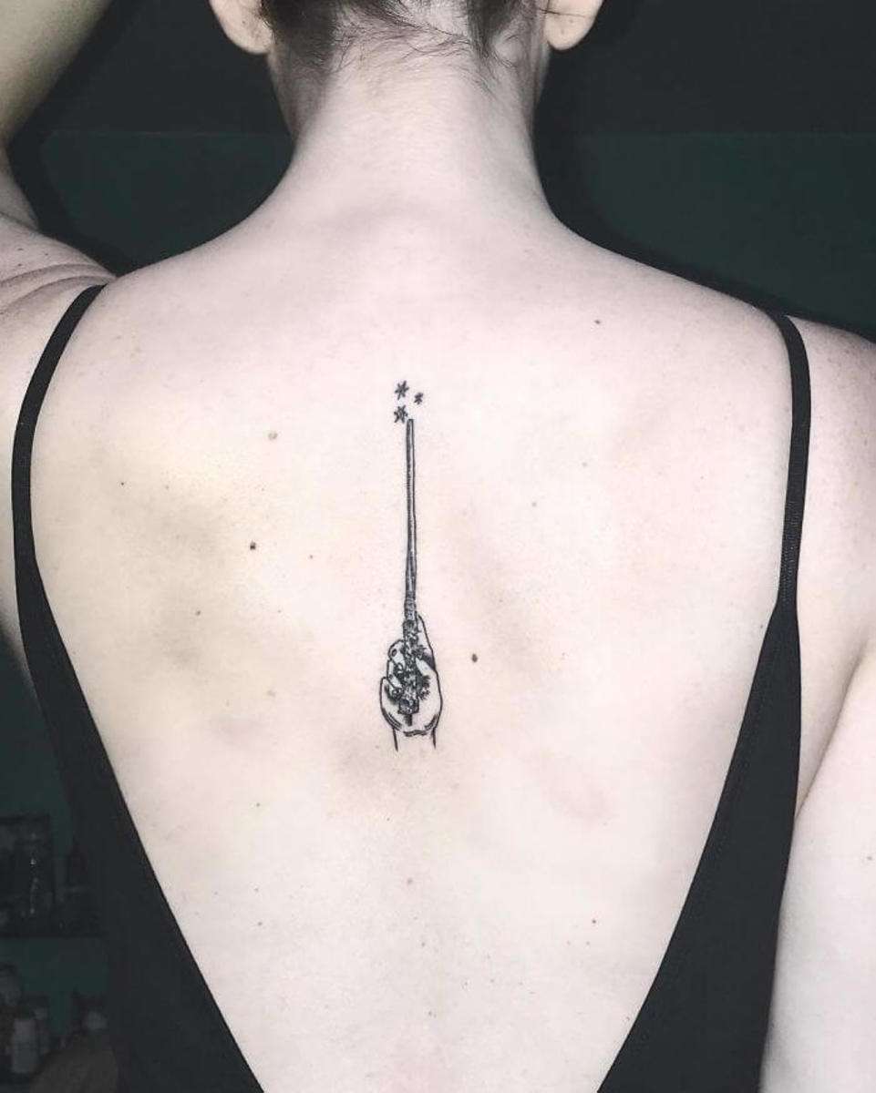 Tatuaje en la columna vertebral: varita mágica