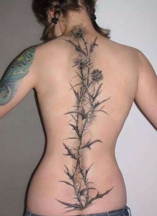 Tatuaje en la columna vertebral, planta con espinas y flores