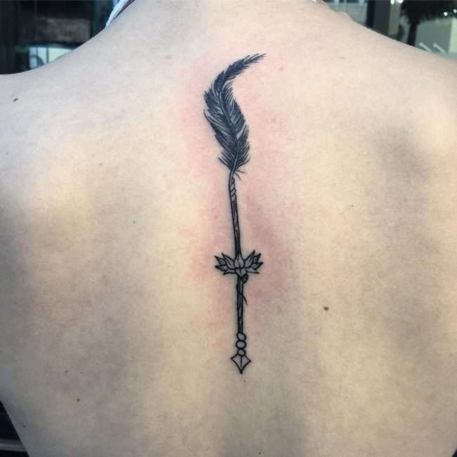 Tatuaje en la columna vertebral: flecha con pluma