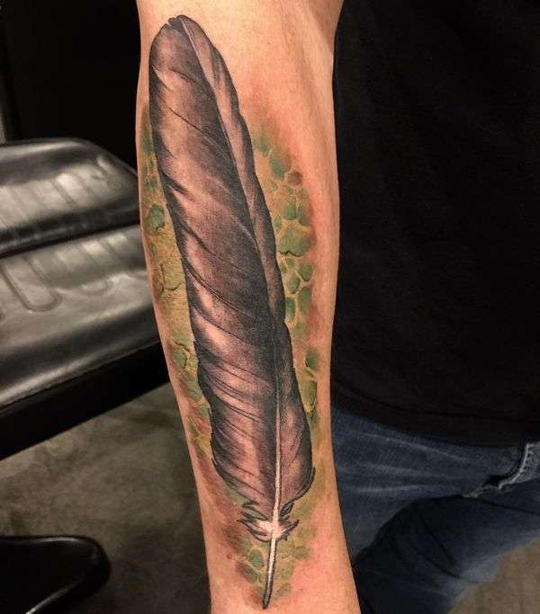 Tatuaje de pluma marrón sobre fondo verde