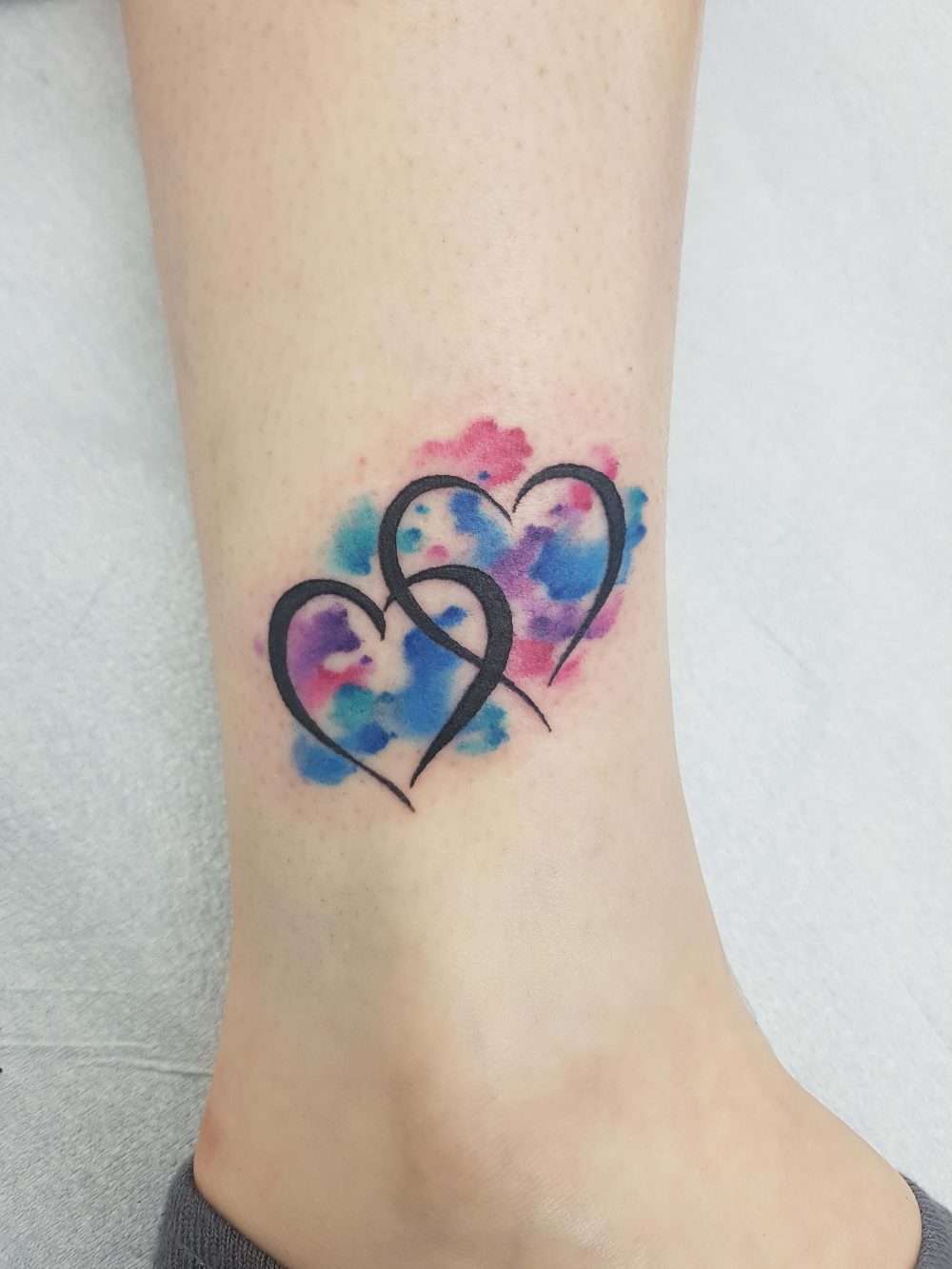 Tatuaje de corazones estilo acuarela