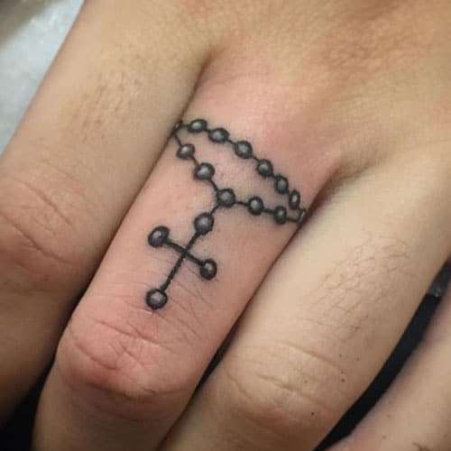 Tatuaje de cruz en el dedo