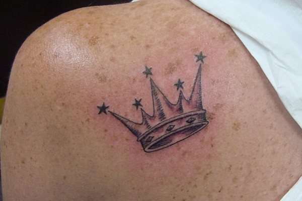 Tatuaje de corona con picos y estrellas
