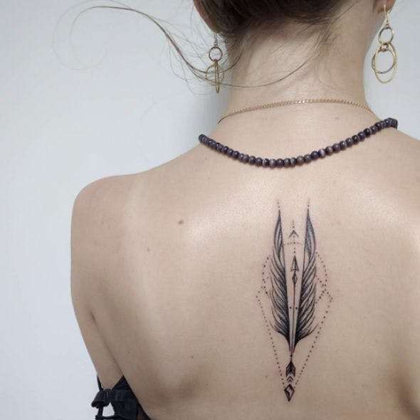 Tatuaje de flecha en la espalda