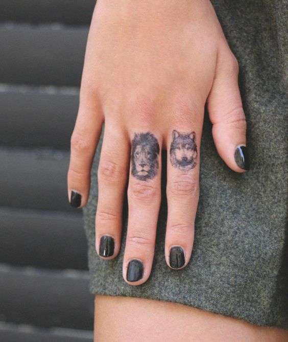 Tatuaje de león y lobo en los dedos