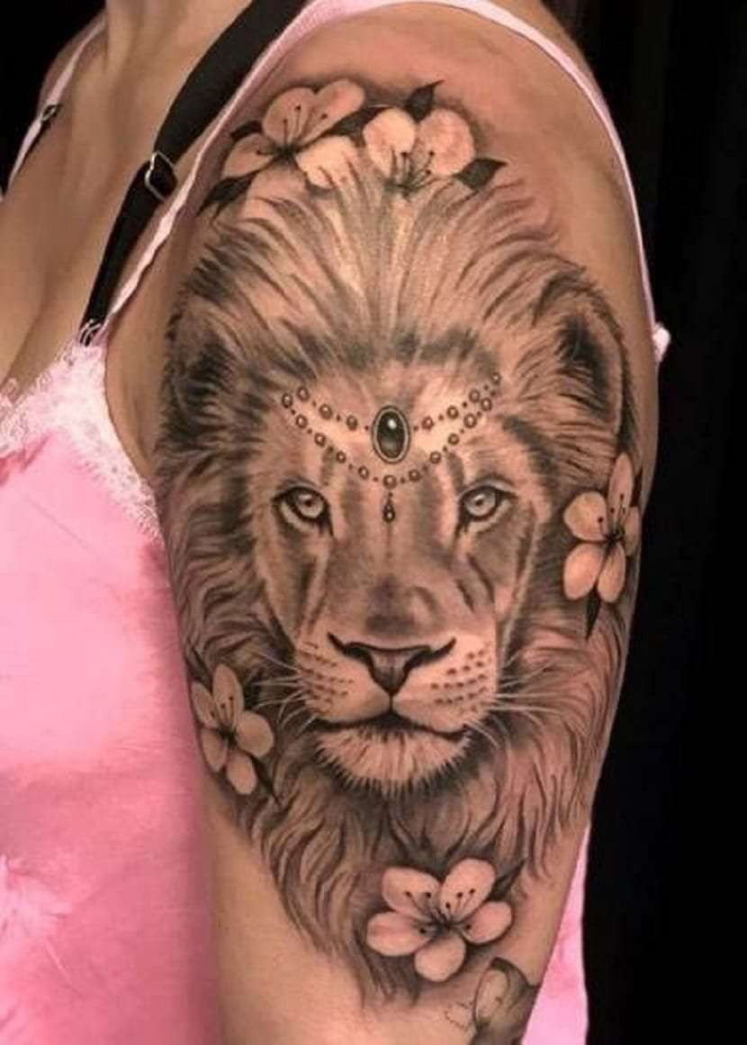 Tatuaje de león en brazo de mujer