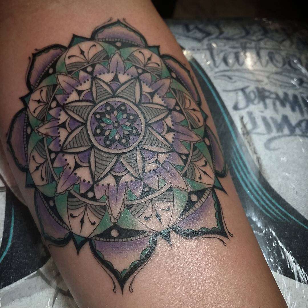 Tatuaje de mandala en verde, violeta y negro