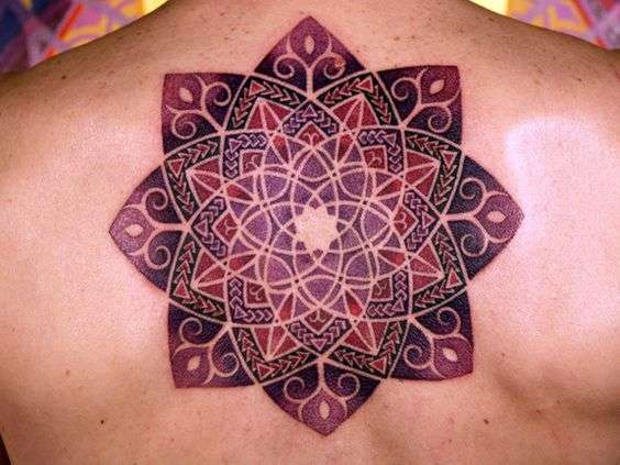 Tatuaje de mandala en colores rojos y violáceos