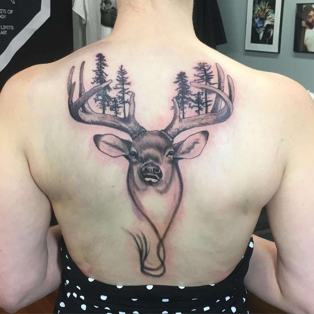 Tatuaje de venado y bosque en la espalda
