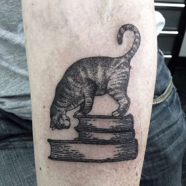 Tatuaje de gato sobre libros