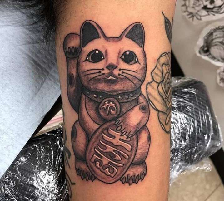 Tatuaje de gato que agita su mano