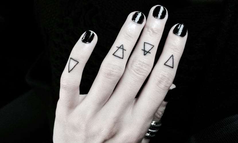 Tatuaje de triángulos en los dedos
