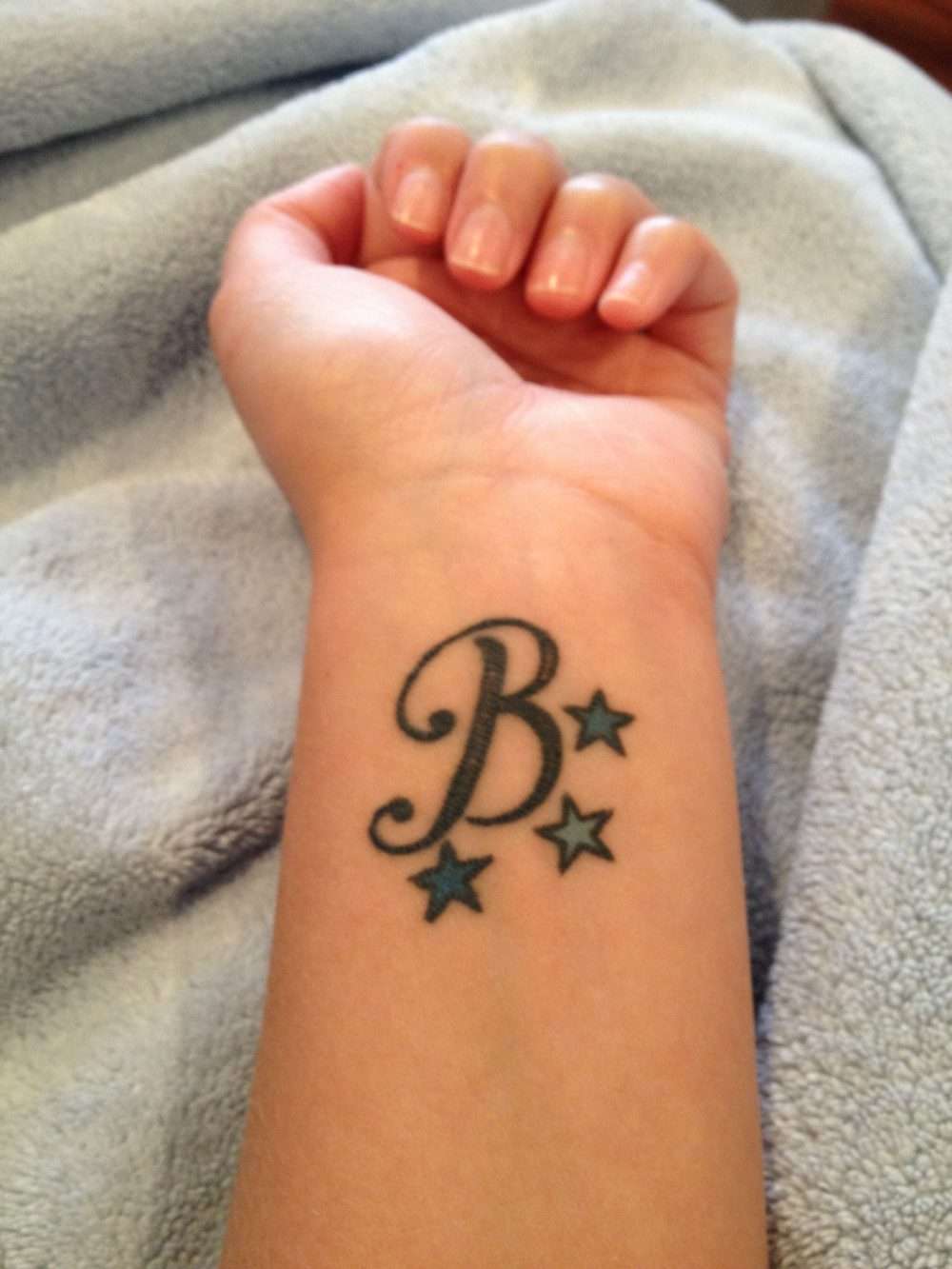 Tatuaje de letra "B" con estrellas