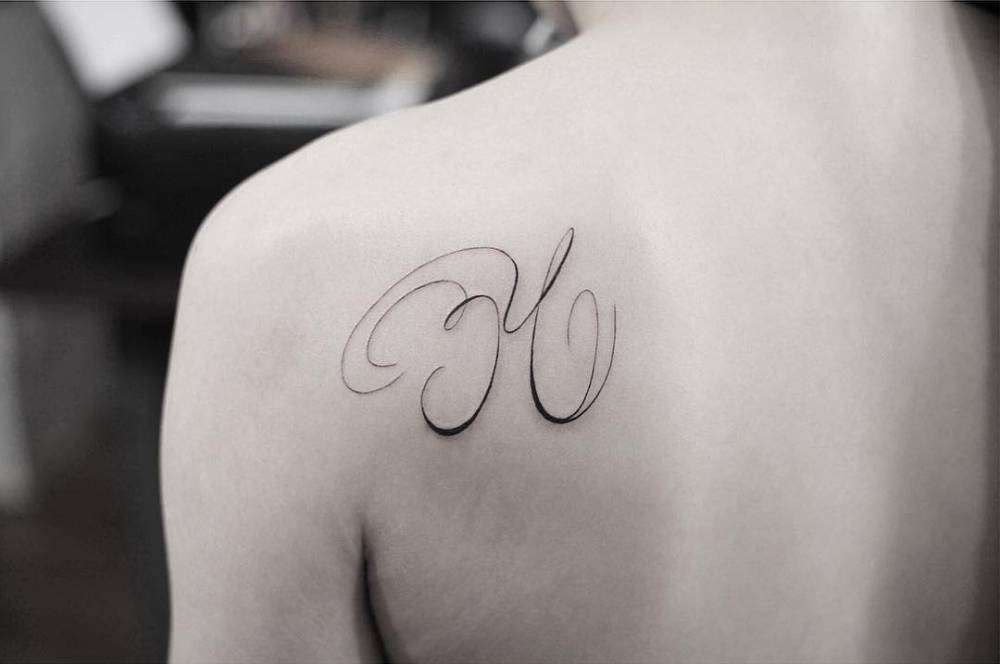 Tatuaje de letra "H" en la espalda