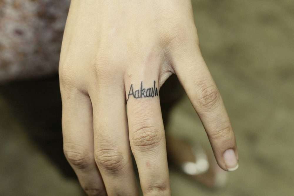 Tatuajes minimalistas: palabra en el dedo